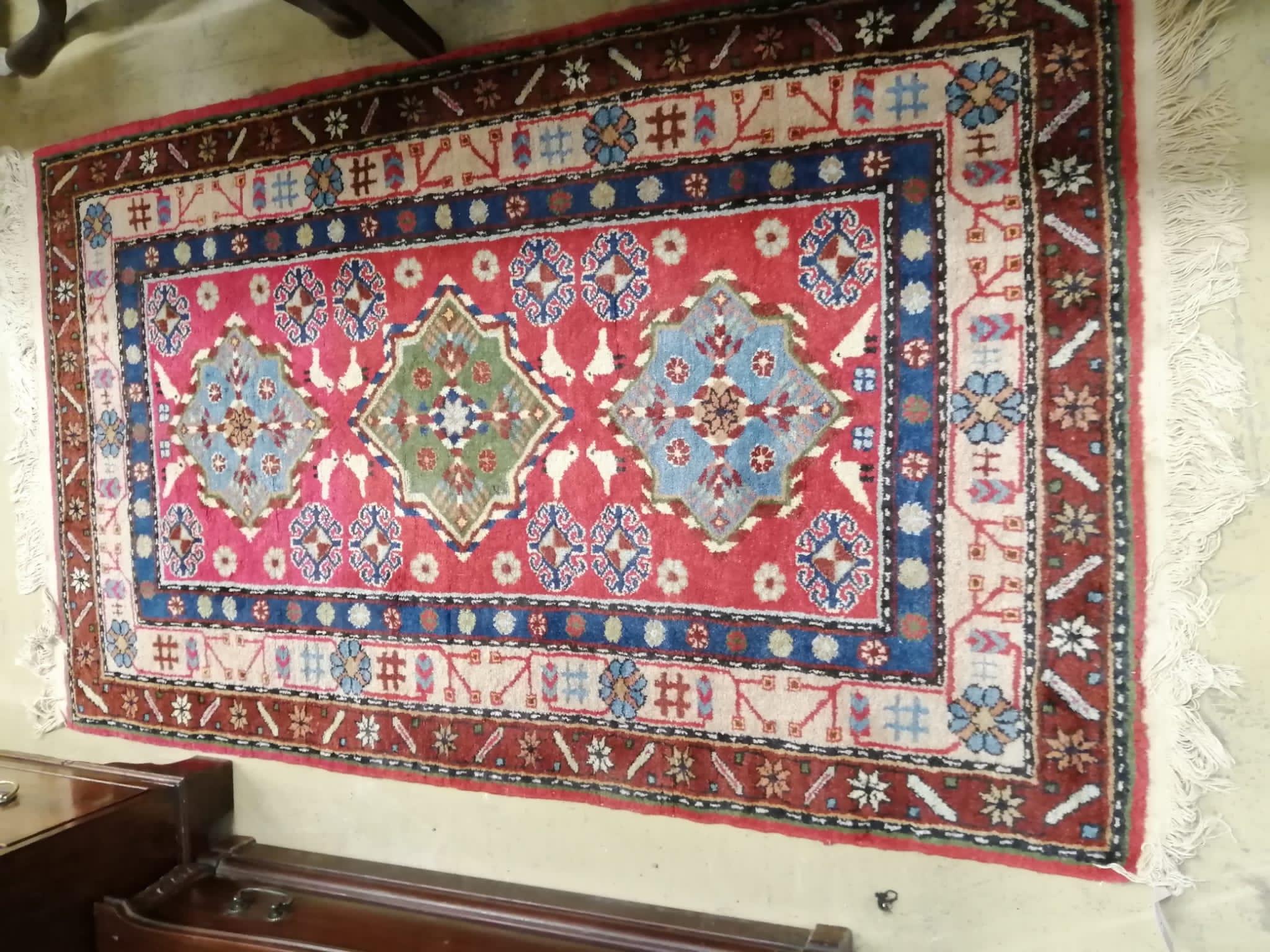 A Caucasian style red ground rug, 155 x 92cm